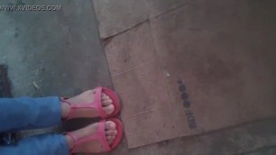 Mis lindos pies en sandalias en la calle