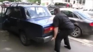 Two beefy European men lifting cars