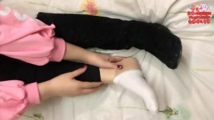 Chinese girl massages her hurt foot wearing white sock over short nylon