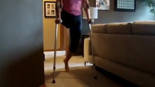 Barefoot Amputee Woman Practices Using Crutches and a Walker