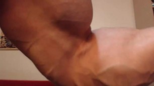 Bodybuilder pumping up biceps, forearms and veins