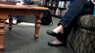 Dangling her flats in library