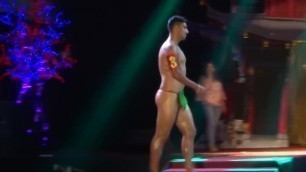Hot young Latinos strut around a stage in just fig leaves