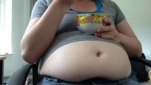 Woman with beer belly stuffing with ice cream