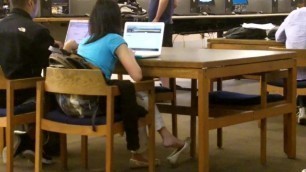 Candid asian girl dangling her flats at the library