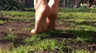 Hot young sexy teen walking on grass with bare feet