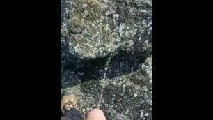 Hands free piss onto a rock and into the wind