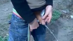 Carefree Russian Guy Peeing on the Grass as His Pal Films It All.