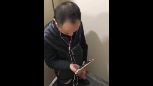 Asian guy jerking in train station toilet