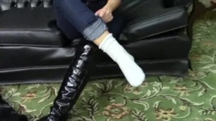 girl hiding her sprained and bandaged ankle beneath white sock and boot