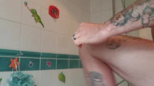 Muscular tattooed guy takes hot shower after the gym
