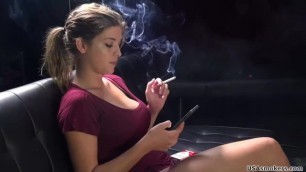 A hot busty girl smokes a cigarette. Sexy big tits make her self-confident.