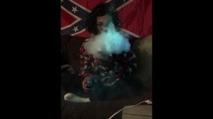 Home girl blowin clouds under  confederate flag