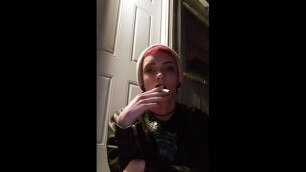 punk smokes a cigarette outside at night
