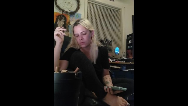 Girl smokes and plays on phone, silver nails