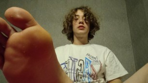 Curly twink shows his legs and jerks off his big dick cumming lots of cum